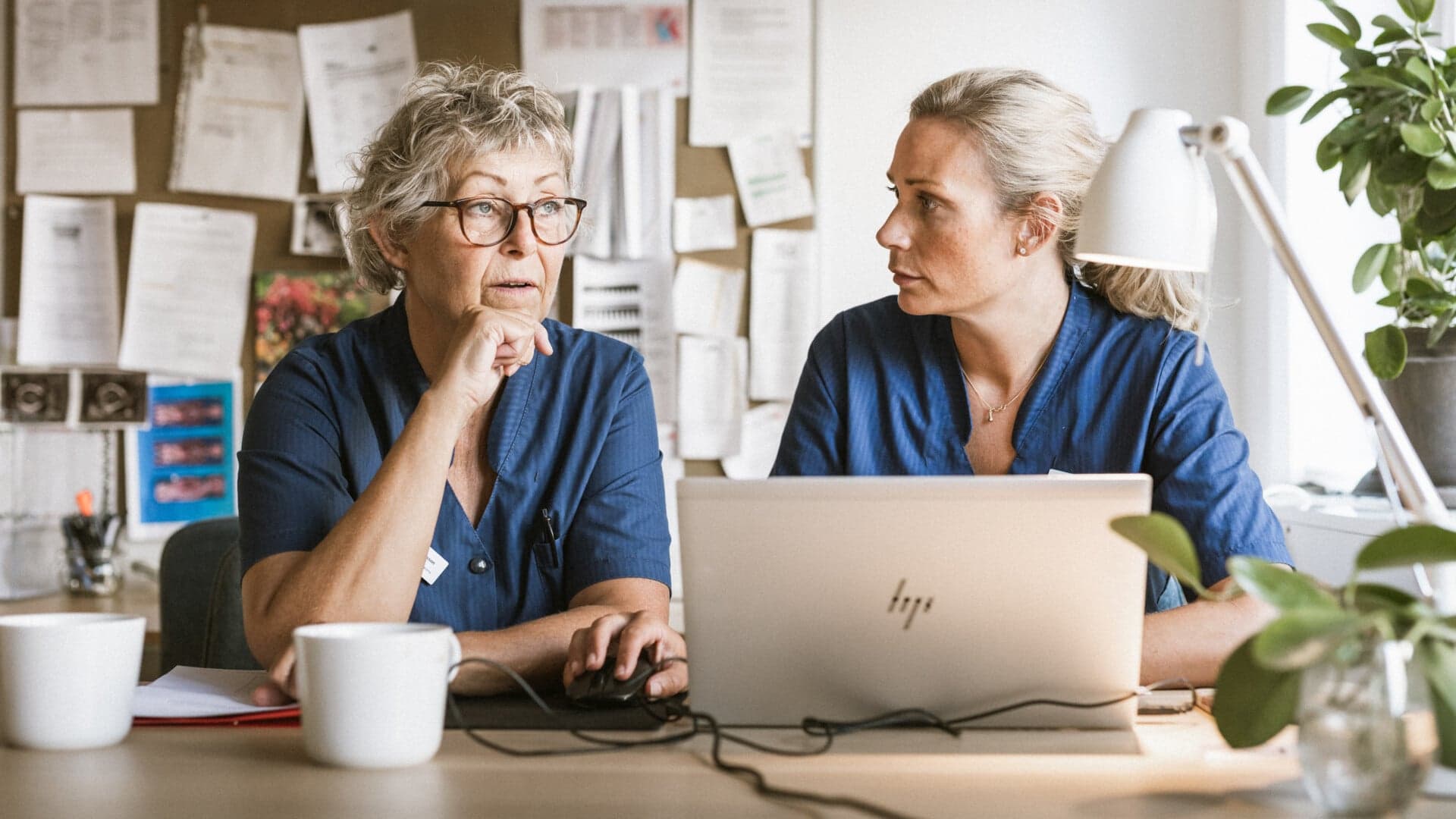 Två kvinnor sitter vid en laptop Två kvinnor sitter vid en laptop